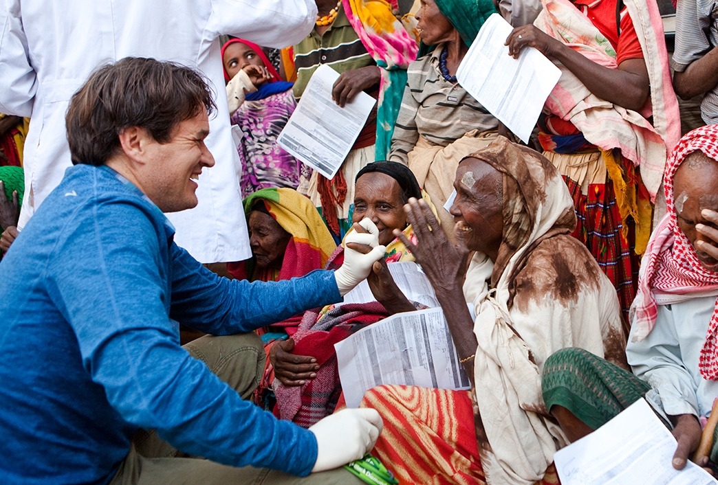 Dr. Matt Oliva interacts with a crowd of happy patients after curing their blindness