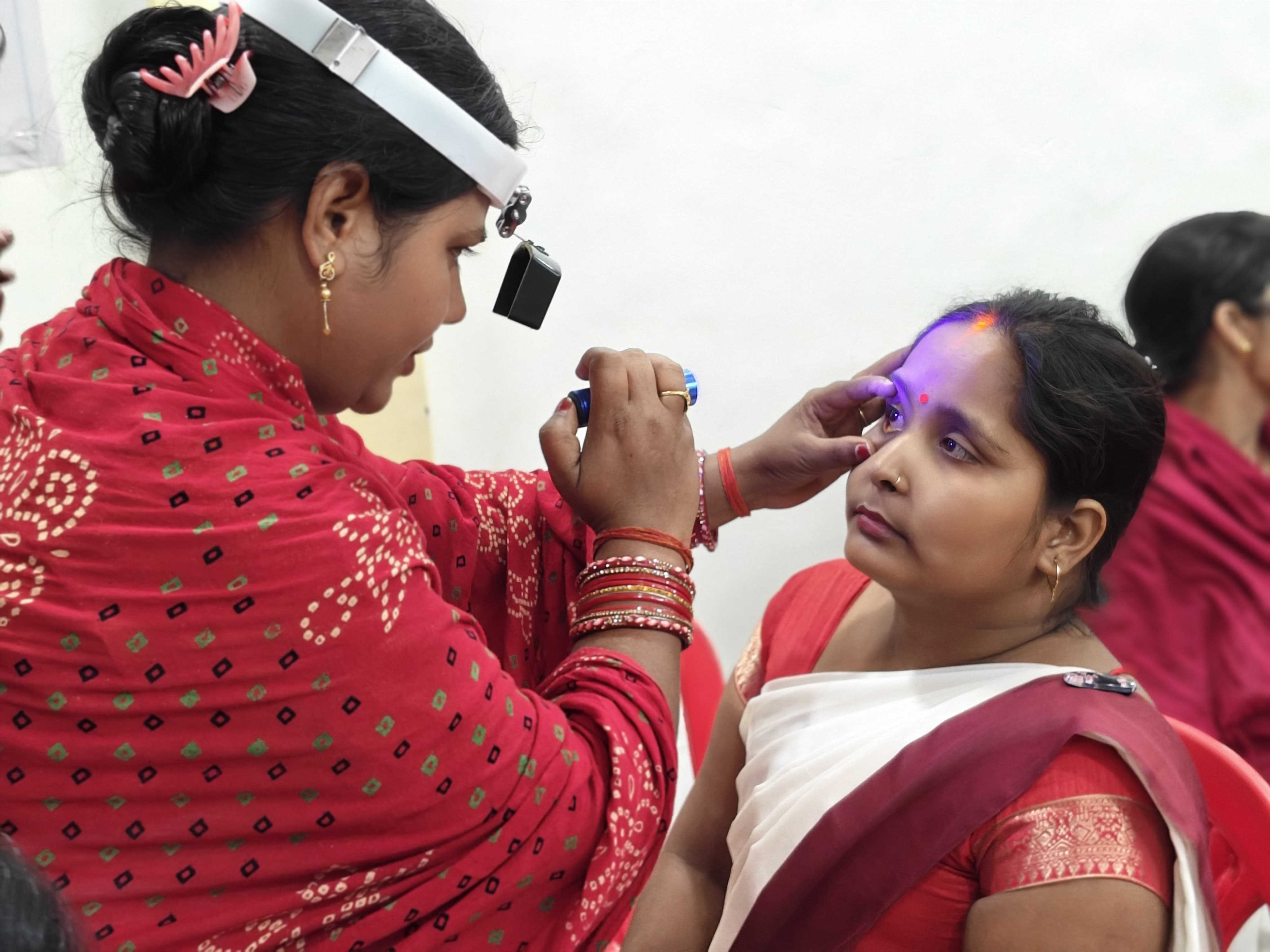 A Community Health Worker leads hands-on eye screening